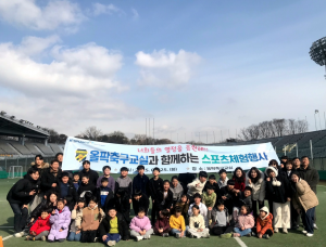 한국체육산업개발 직원 및 지역아동센터 아동과 선생님들이 스포츠체험행사 단체 사진을 찍고 있다