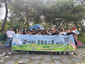 ‘걸어서 충북속으로-괴산호’ 프로그램에 참가한 청소년들이 괴산 산막이옛길 앞에서 기념사진을 촬영하고 있다