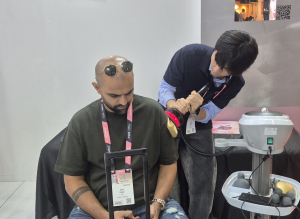 ONEWAYLAB team member demonstrating the company’s flagship device to visitors at the Beautyworld Middle East 2025 booth