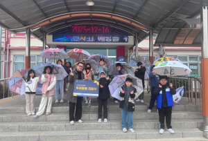 2025년 12월 16일 겨울 비 내리는 날 신북초등학교 학생들이 폐현수막 새활용 우산을 쓰고 귀가 준비를 하고 있는 모습