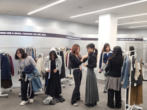 패션디자인서포터즈 대학생 멘토들이 동대문디자인플라자(DDP) 쇼룸 샘플스토어에서 청소년 참가자들의 조별 콘셉트에 맞춰 의상 선택과 스타일링을 도와주며 룩북 촬영 체험을 하고 있다