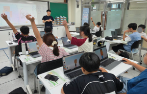 진천상신초등학교 학생들이 디지털새싹 수업 중 마인크래프트 에듀케이션의 캐릭터 스킨을 AI를 활용해 제작하는 과정에서 강사의 질문에 손을 들어 답하고 있다