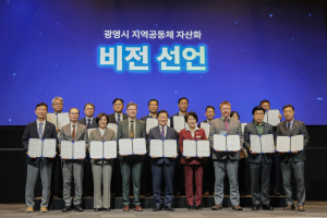 ‘2026 광명시 지역공동체 자산화 국제포럼’에 참석한 연사들이 지역공동체 자산화 비전 선언문을 낭독한 뒤 단체촬영을 하고 있다